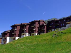 an apartment building on top of a green hill at Appartement Valmorel, 1 pièce, 4 personnes - FR-1-291-769 in Valmorel