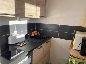 a small kitchen with black and white tiles at Maxi Studio à Orcières : 4 pers, proche des pistes, lumineux avec 2 balcons & Wi-Fi - FR-1-262-99 in Forest des Baniols +4 photos