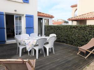 une table à manger blanche et des chaises sur une terrasse dans l'établissement Maison Bretignolles-sur-Mer, 4 pièces, 6 personnes - FR-1-224A-26, à Bretignolles-sur-Mer