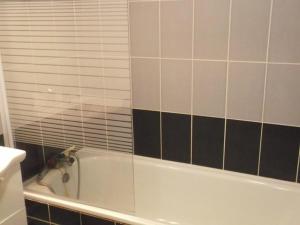 ein Badezimmer mit einer Badewanne und einer gefliesten Wand in der Unterkunft Maxi studio lumineux pour 4 pers. à Orcières Merlette, proche pistes et commerces, loggia sud - FR-1-262-128 in Forest des Baniols