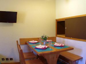 a dining room table with two chairs and a television at Appartement Valmorel, 1 pièce, 4 personnes - FR-1-291-783 in Valmorel