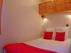sypialnia z łóżkiem z 2 czerwonymi poduszkami w obiekcie Appartement Valmorel, 3 pièces, 8 personnes - FR-1-291-759 w mieście Valmorel
