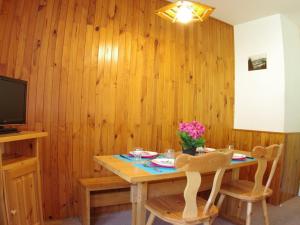 a wooden dining room with a table and two chairs at Appartement Valmorel, 2 pièces, 6 personnes - FR-1-291-764 in Valmorel