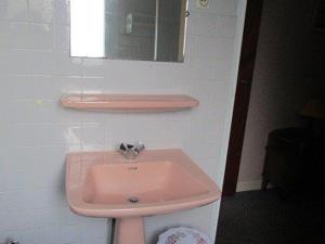 uma casa de banho com um lavatório rosa e um espelho. em Appartement Cauterets, 3 pièces, 4 personnes - FR-1-234-141 em Cauterets