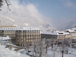 un edificio ricoperto di neve con una montagna sullo sfondo di Appartement Cauterets, 2 pièces, 5 personnes - FR-1-234-145 a Cauterets
