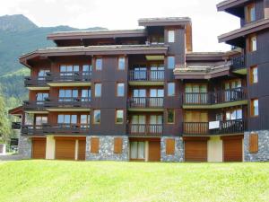 ein großes Gebäude mit einem Grasfeld davor in der Unterkunft Studio cosy, animaux admis, parking disponible, Valmorel - FR-1-291-768 in Valmorel