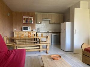 Appartement 2 pièces cabine 8 pers, proche pistes et commerces, Orcières - FR-1-262-87 في Forest des Baniols: مطبخ مع طاولة وثلاجة بيضاء