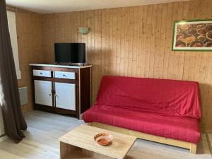 Appartement 2 pièces cabine 8 pers, proche pistes et commerces, Orcières - FR-1-262-87 في Forest des Baniols: غرفة بسرير احمر وطاولة