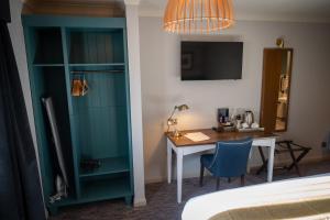 um quarto de hotel com uma secretária e um quarto com uma cama em Ely Hotel by Chef & Brewer Collection em Camberley