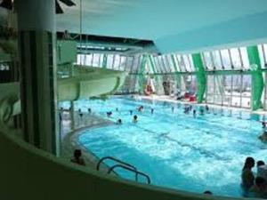 una gran piscina en un edificio con gente dentro en Appartement Orcières Merlette, 2 pièces, 8 personnes - FR-1-262-87, en Forest des Baniols
