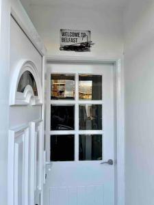 a white door with a sign on top of it at Stay-K-Belfast Cosy house 10 mins from city centre in Belfast