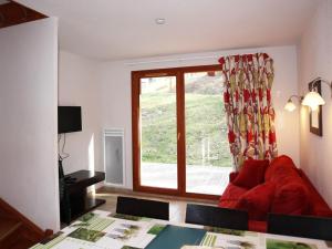 a living room with a red couch and a window at Chalet Les Orres, 3 pièces, 6 personnes - FR-1-322-57 in Les Orres