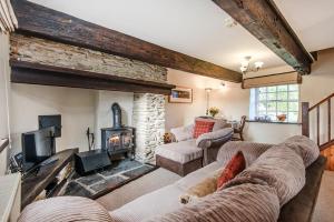 a living room with two couches and a fireplace at Clydey Cottages Pembrokeshire in Pembrokeshire