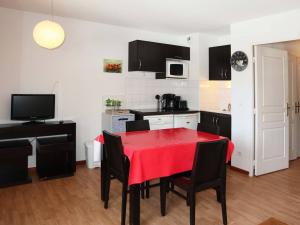 a kitchen with a table with a red table cloth on it at Appartement Les Orres, 2 pièces, 4 personnes - FR-1-322-69 in Les Orres