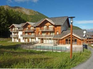a large wooden house with a fence in front of it at Appartement Les Orres, 2 pièces, 4 personnes - FR-1-322-74 in Les Orres