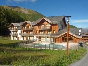 a large building with a pool in front of a mountain at Appartement Les Orres, 2 pièces, 4 personnes - FR-1-322-75 in Les Orres