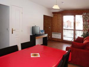 a living room with a red table and a television at Appartement Les Orres, 2 pièces, 4 personnes - FR-1-322-75 in Les Orres