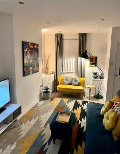 a living room with a couch and a tv at Stay-K-Belfast Cosy house 10 mins from city centre in Belfast