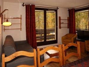 a living room with a couch and a chair and windows at Appartement Les Orres, 2 pièces, 6 personnes - FR-1-322-83 in Les Orres