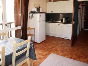 a kitchen with a white refrigerator and a table at Appartement Les Orres, 1 pièce, 4 personnes - FR-1-322-97 in Les Orres