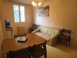 uma sala de estar com uma mesa e um sofá em Appartement Cauterets, 3 pièces, 5 personnes - FR-1-234-138 em Cauterets