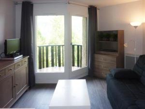 ein Wohnzimmer mit einem Sofa und einer Glasschiebetür in der Unterkunft Studio Les Orres, 1 pièce, 4 personnes - FR-1-322-115 in Les Orres