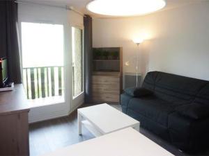 ein Wohnzimmer mit einem schwarzen Sofa und einem Fenster in der Unterkunft Studio Les Orres, 1 pièce, 4 personnes - FR-1-322-115 in Les Orres