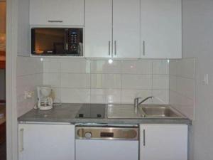 a kitchen with white cabinets and a sink at Studio Les Orres, 1 pièce, 4 personnes - FR-1-322-115 in Les Orres