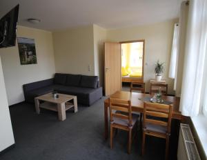 ein Wohnzimmer mit einem Sofa und einem Tisch in der Unterkunft Bürger- und Berggasthaus Scheibenberg in Scheibenberg