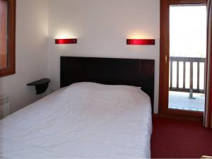 ein Schlafzimmer mit einem weißen Bett und einem Fenster in der Unterkunft Chalet Les Orres, 3 pièces, 6 personnes - FR-1-322-121 in Les Orres