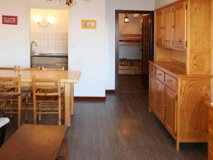 - une cuisine avec des placards en bois, une table et des chaises dans l'établissement Appartement Les Orres, 2 pièces, 6 personnes - FR-1-322-29, aux Orres