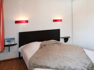 ein Schlafzimmer mit einem Bett mit zwei roten Lichtern an der Wand in der Unterkunft Appartement Les Orres, 2 pièces, 4 personnes - FR-1-322-130 in Les Orres