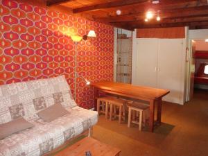 ein Wohnzimmer mit einem Tisch und einem Sofa in der Unterkunft Appartement Les Orres, 1 pièce, 4 personnes - FR-1-322-190 in Les Orres