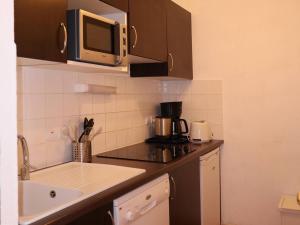 a kitchen with a sink and a microwave at Appartement Les Orres, 2 pièces, 4 personnes - FR-1-322-38 in Les Orres