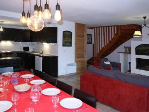 a dining room with a red table and a kitchen at Chalet Les Orres, 5 pièces, 10 personnes - FR-1-322-65 in Les Orres