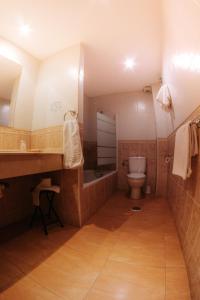 a bathroom with a toilet and a sink and a tub at Hotel Delphos in Moraleja
