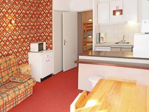 a kitchen and a living room with a couch at Appartement Les Orres, 1 pièce, 4 personnes - FR-1-322-267 in Les Orres