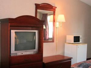 Habitación de hotel con TV y cama en Shayona Inn - Eden en Eden