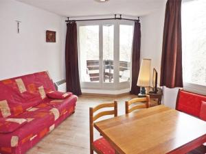 a living room with a red couch and a table at Appartement Les Orres, 1 pièce, 4 personnes - FR-1-322-271 in Les Orres