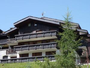 un edificio de apartamentos con balcones y un árbol en Appartement Valmorel, 3 pièces, 6 personnes - FR-1-291-795, en Valmorel