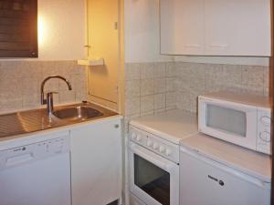 eine Küche mit einer Spüle und einer Mikrowelle in der Unterkunft Appartement Les Orres, 2 pièces, 6 personnes - FR-1-322-204 in Les Orres