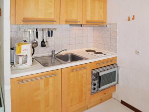 a kitchen with wooden cabinets and a sink at Appartement Les Orres, 1 pièce, 4 personnes - FR-1-322-126 in Les Orres