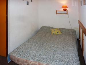 a small bedroom with a bed with a yellow pillow at Appartement Les Orres, 1 pièce, 6 personnes - FR-1-322-145 in Les Orres