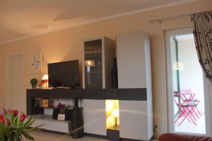 ein Wohnzimmer mit einem TV und einem Schrank in der Unterkunft Großzügige Ferienwohnung im OT Bad, Strandnähe in Sankt Peter-Ording