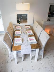 a dining room table with two chairs and a table with dishes on it at Grosszuegige-Ferienwohnung-im-OT-Bad-Strandnaehe in Sankt Peter-Ording