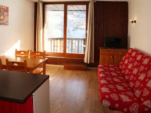 a living room with a red couch and a table at Appartement Les Orres, 1 pièce, 4 personnes - FR-1-322-151 in Les Orres