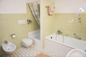 ein Badezimmer mit einem WC, einer Badewanne und einem Waschbecken in der Unterkunft Großzügige Ferienwohnung im OT Bad, Strandnähe in Sankt Peter-Ording