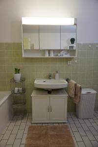 a bathroom with a sink and a mirror and a tub at Grosszuegige-Ferienwohnung-im-OT-Bad-Strandnaehe in Sankt Peter-Ording