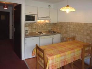 a kitchen with a table and a sink and a stove at Appartement Les Orres, 1 pièce, 4 personnes - FR-1-322-175 in Les Orres