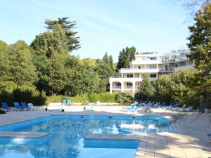 una piscina con sillas y un edificio de fondo en Appartement La Baule, 2 pièces, 3 personnes - FR-1-245-34, en La Baule